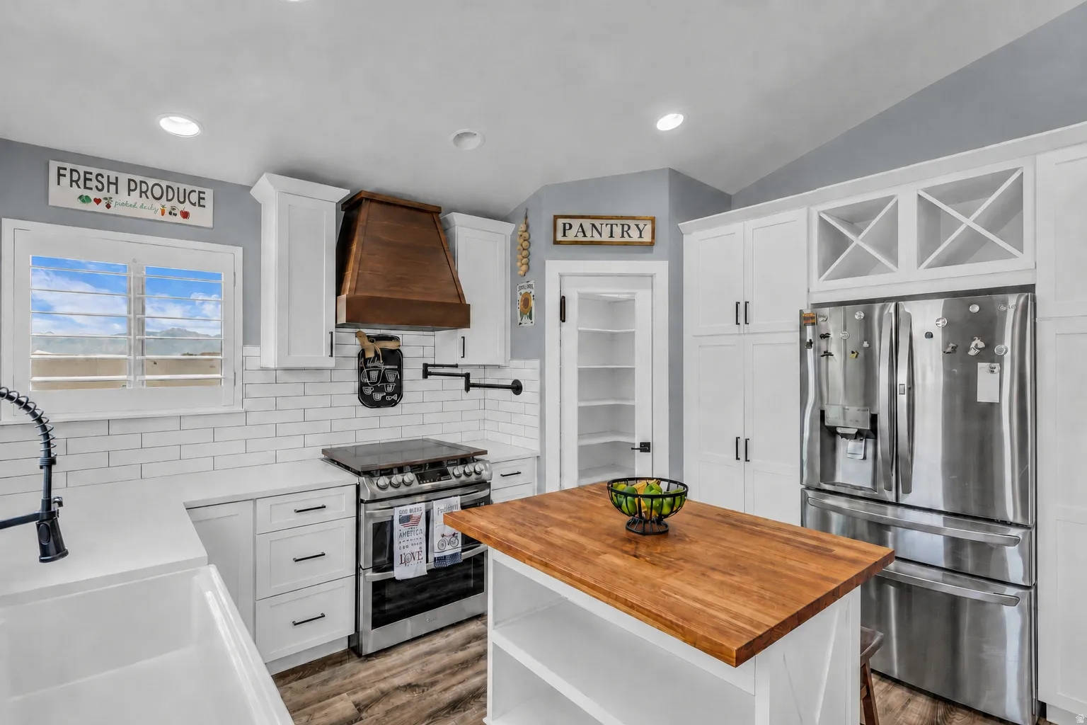 Kitchen featuring white cabinetry, wood-finish flooring, and subway tile backsplash