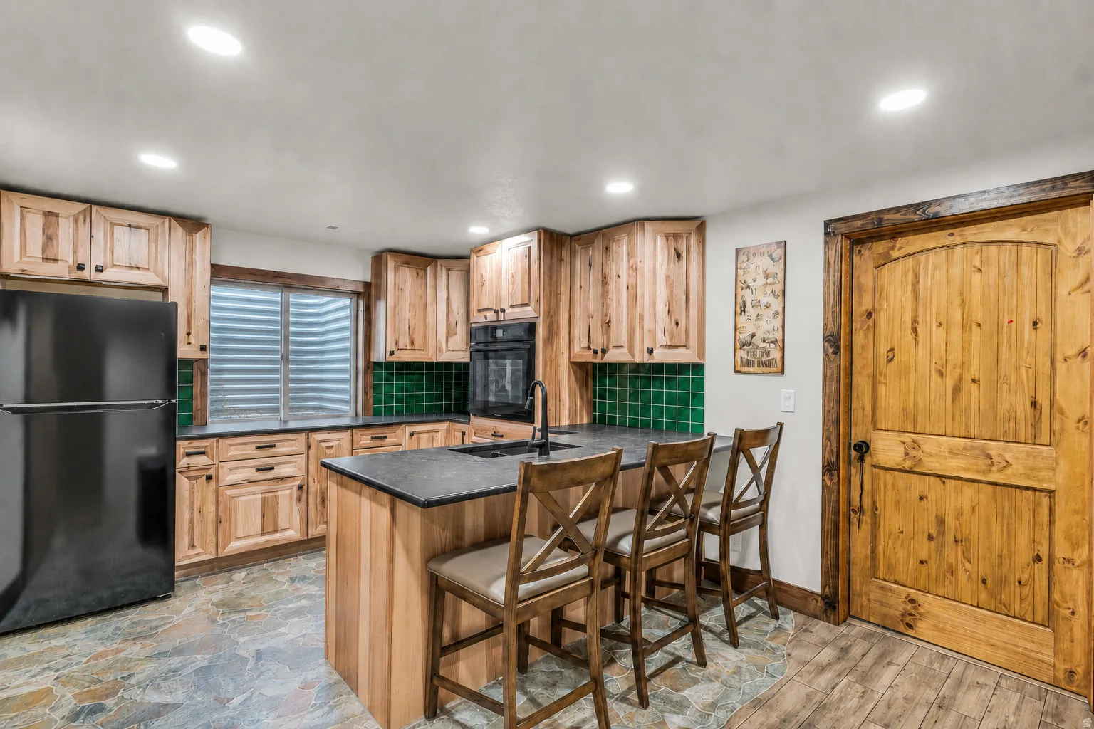 Kitchen featuring natural wood cabinetry and a central island with bar seating