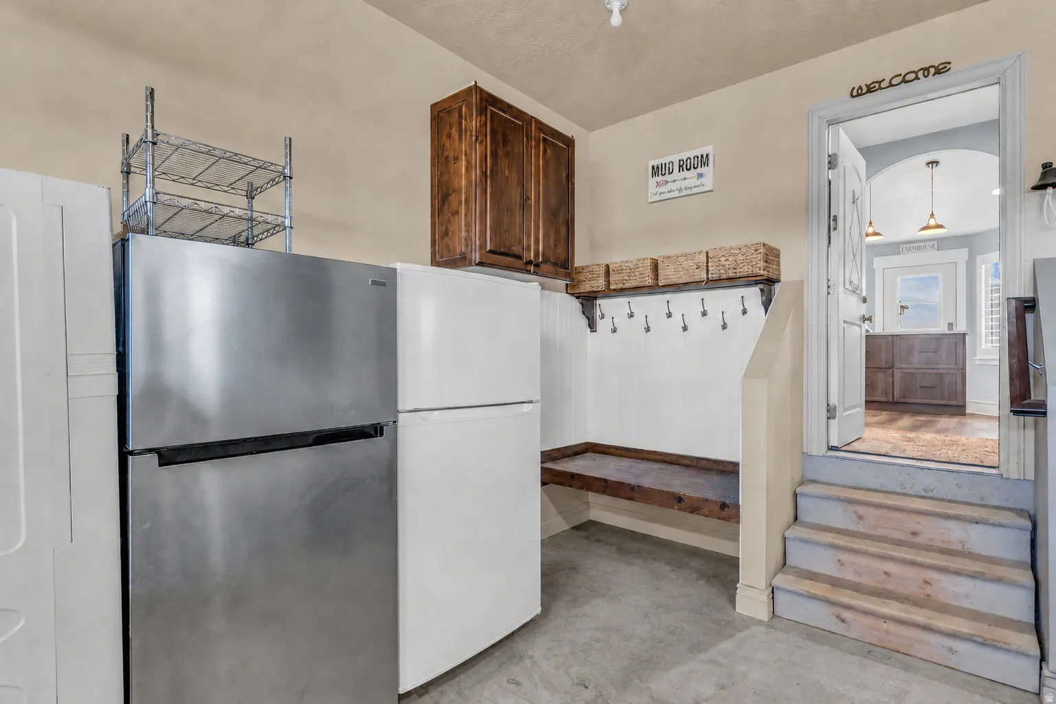 Dedicated mudroom area featuring a built-in bench, coat hooks, and overhead shelving