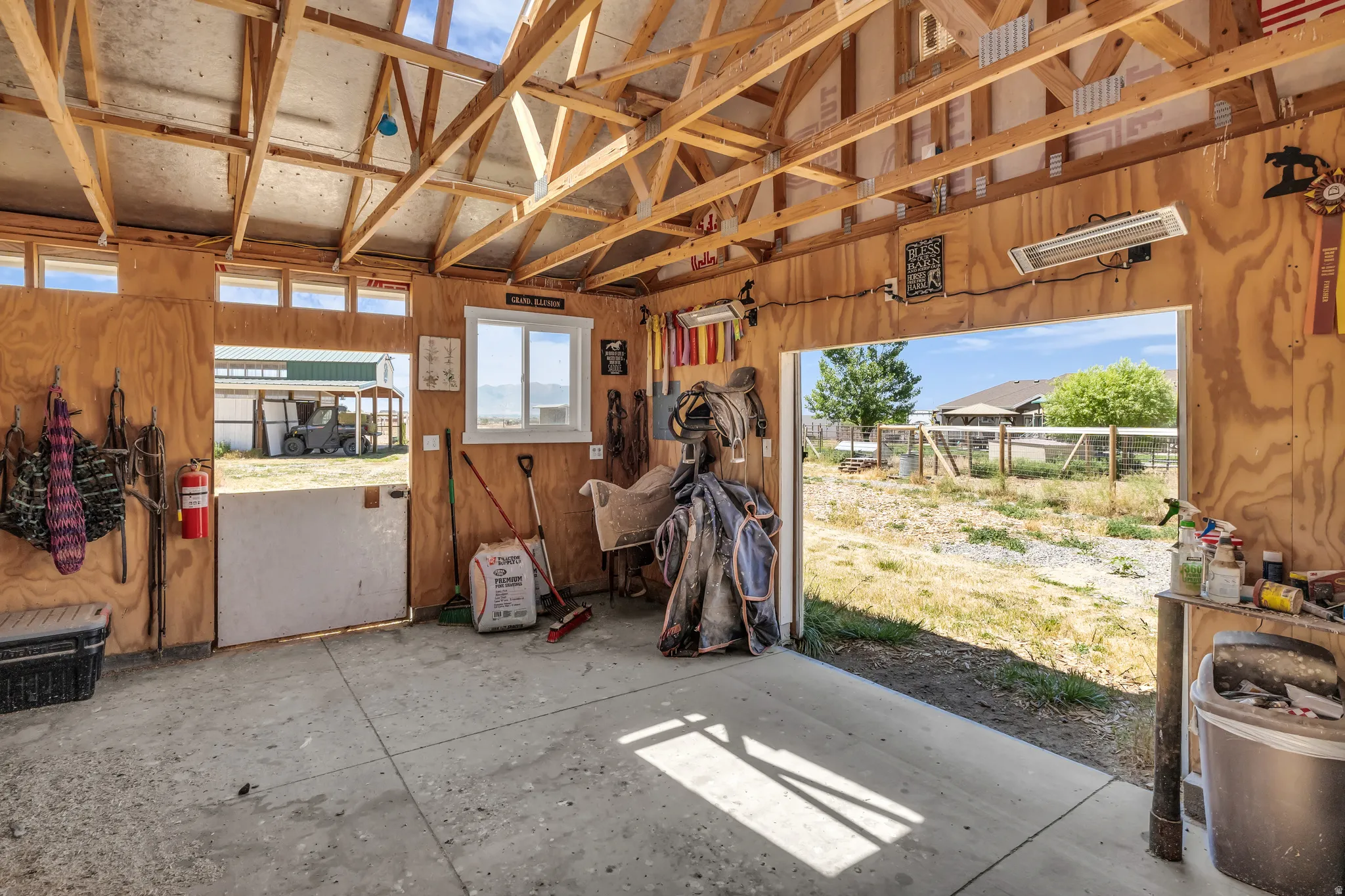 Utility building featuring a concrete floor, exposed wood beam ceiling, and plywood panel walls