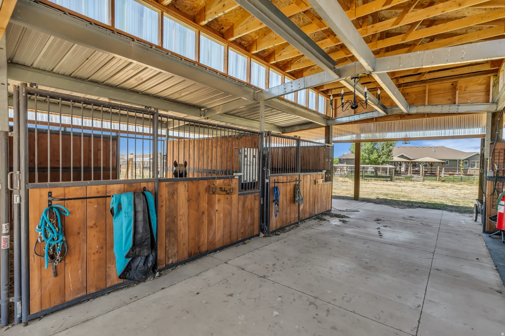 Equestrian facility featuring multiple stalls with wood paneling and metal bars