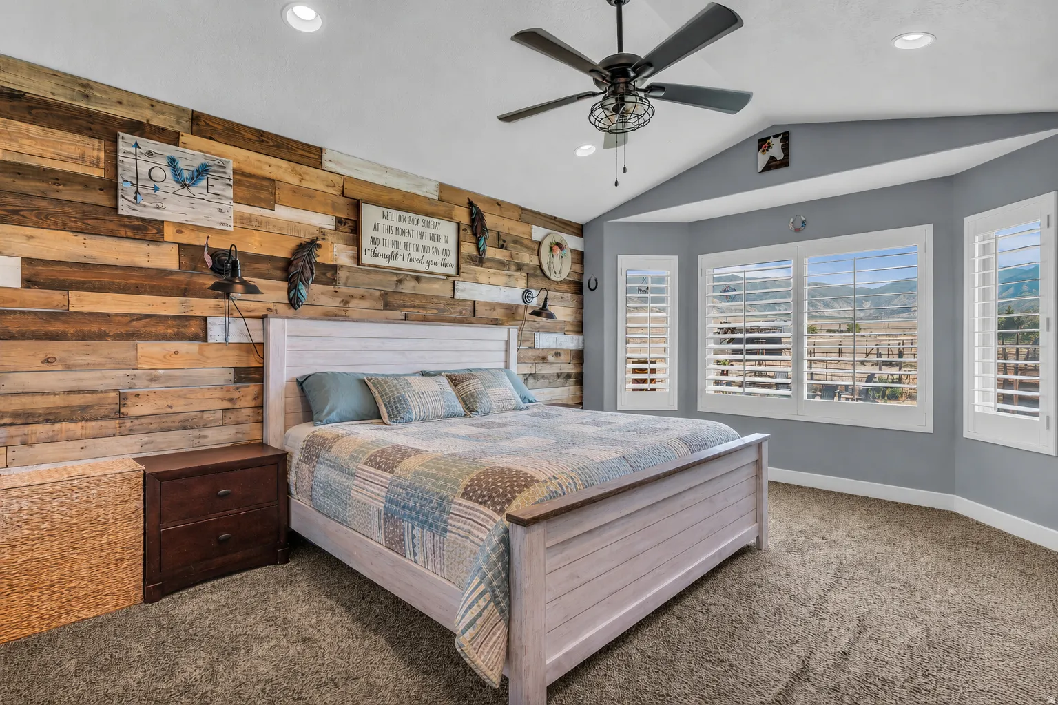 Vaulted ceiling bedroom featuring a textured wood accent wall, recessed lighting, and a ceiling fan