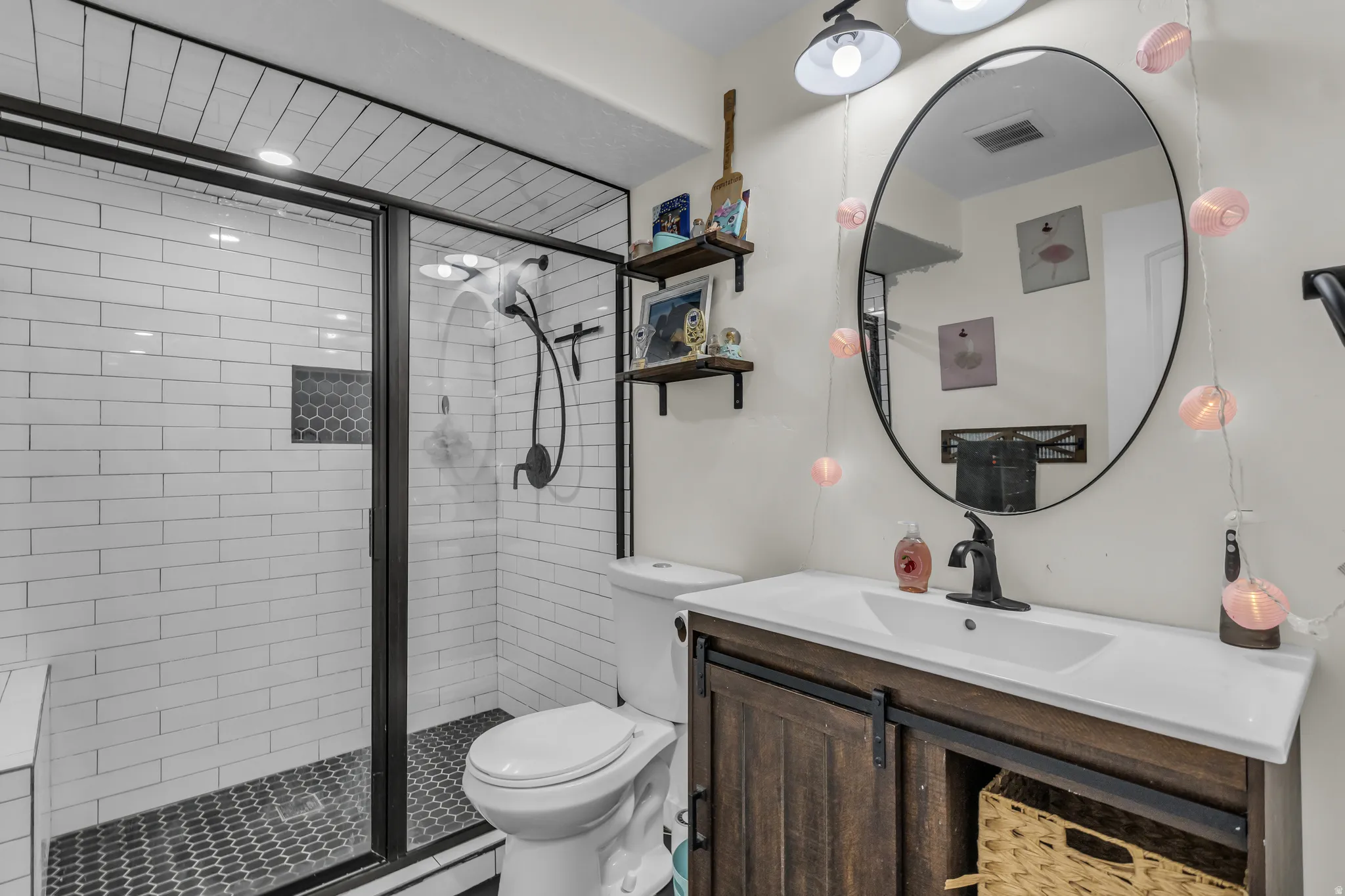 Bathroom featuring a walk-in shower with subway tile surround and dark hexagon tile flooring