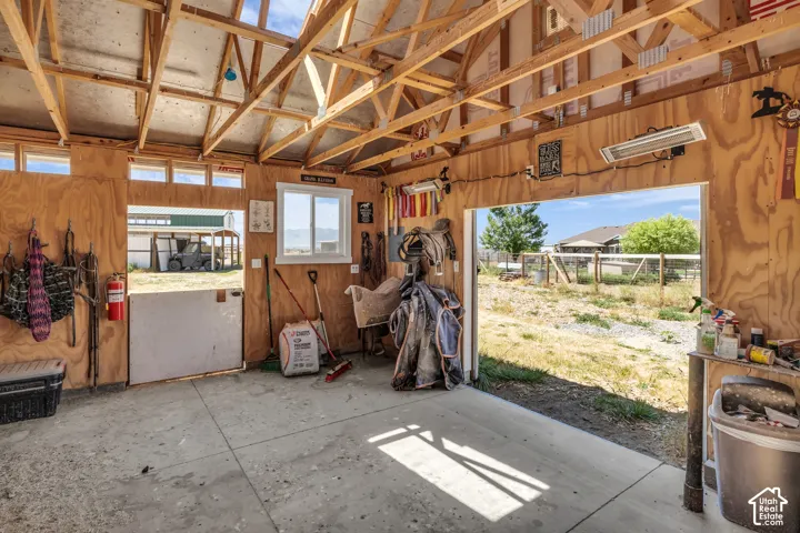 Utility building featuring a concrete floor, exposed wood beam ceiling, and plywood panel walls