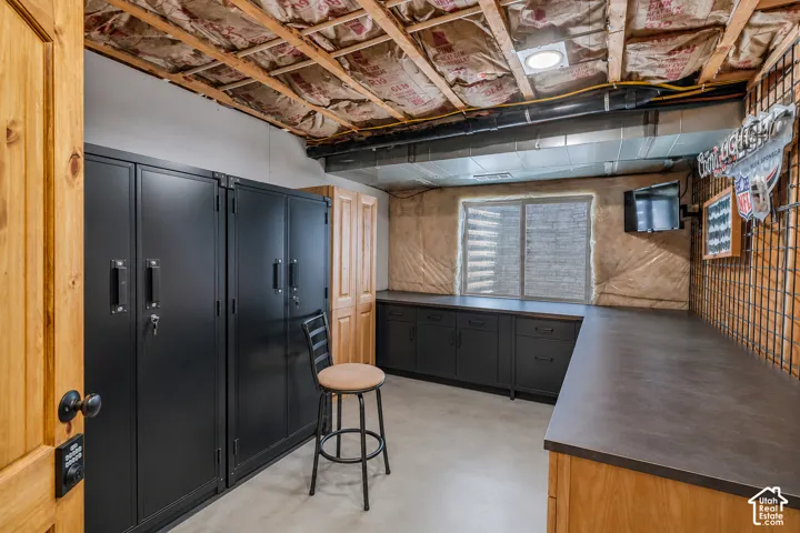 Virtually cleared of items and decor. Utility room featuring extensive dark-finish cabinetry with integrated countertops