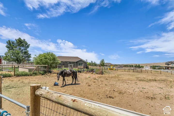 Expansive outdoor area featuring a fenced paddock with a lean-to structure, wood post and wire fencing, and surrounding open terrain