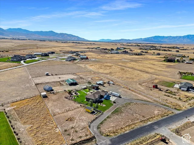 Expansive rural property featuring a main residence, multiple outbuildings, and a paved driveway