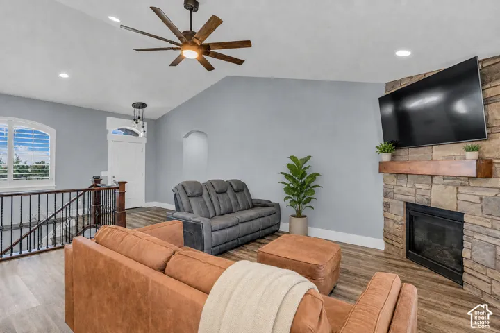 Virtually cleared of items and decor. Vaulted ceiling with an integrated ceiling fan and recessed lighting, gas fireplace