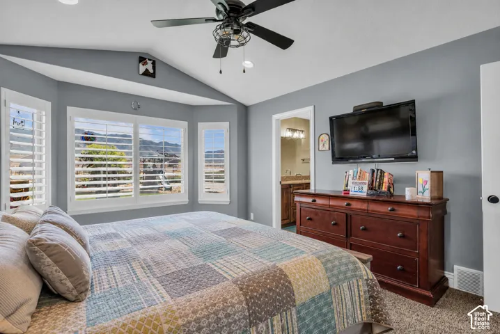 Virtually cleared of items and decor. Bedroom featuring a vaulted ceiling, ceiling fan with integrated lighting, and a bay window with plantation shutters