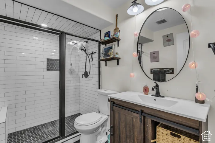 Bathroom featuring a walk-in shower with subway tile surround and dark hexagon tile flooring
