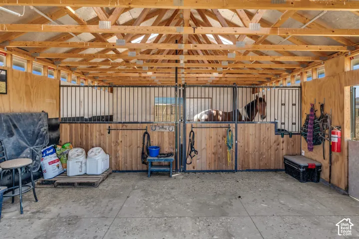 Open-air barn structure featuring exposed wood framing and a concrete floor