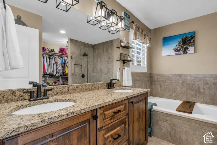 Virtually cleared of items and decor. Double vanity with granite countertops and dark wood cabinetry, large soaker tub.