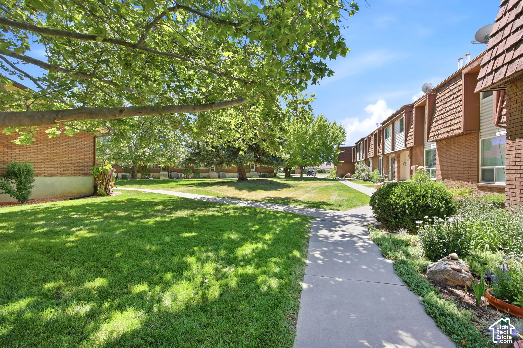 Landscaped grounds featuring mature trees and green lawns
