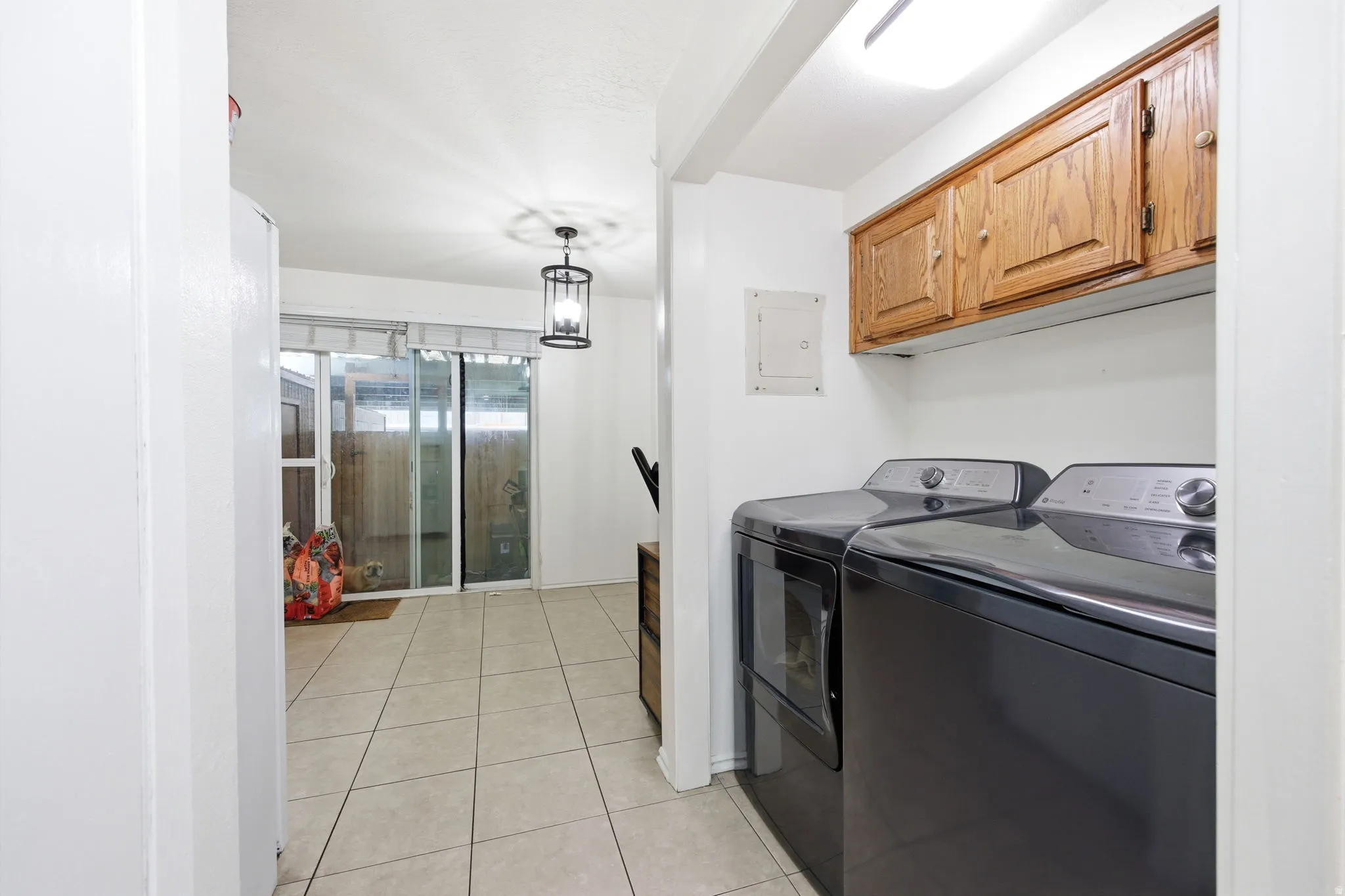 Laundry area featuring wood-finish cabinetry and built-in overhead lighting