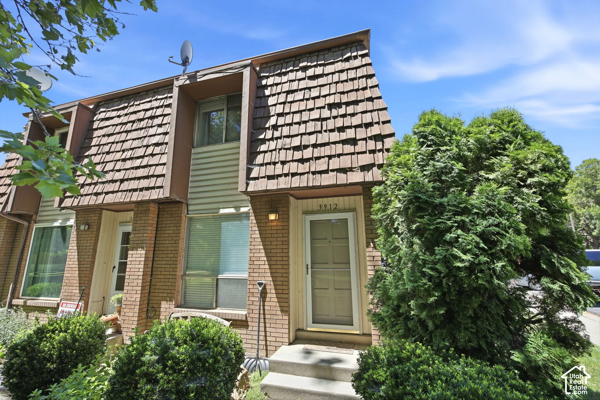 Brick exterior with a prominent A-frame roofline featuring wood shake shingles