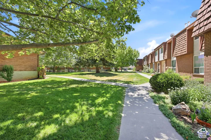 Landscaped grounds featuring mature trees and green lawns