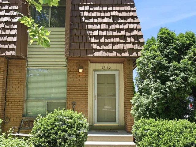 Brick facade featuring a distinct Mansard roofline