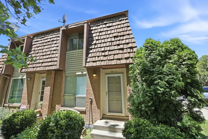 Brick exterior with a prominent A-frame roofline featuring wood shake shingles