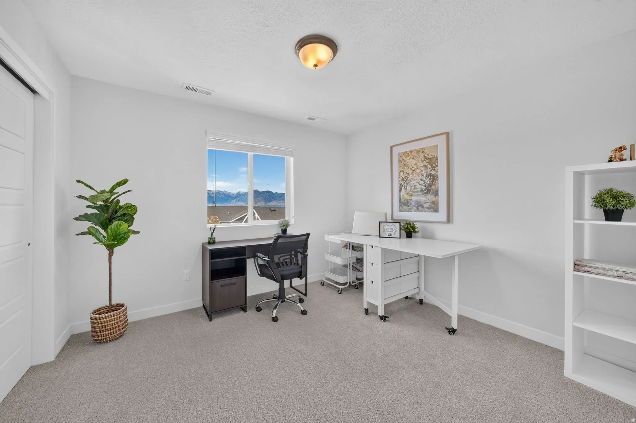 Bright room featuring a large window, neutral wall paint, and light-colored carpeting