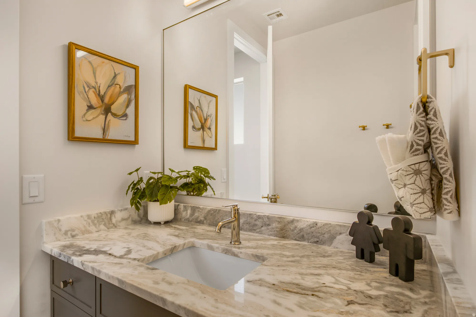 Vanity featuring a patterned stone countertop and integrated sink