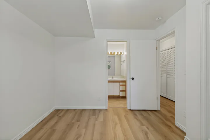 Wood-finish flooring throughout, white walls, and white trim