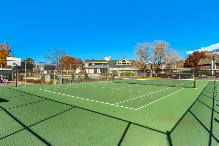 Outdoor tennis court featuring green surfacing and white court lines