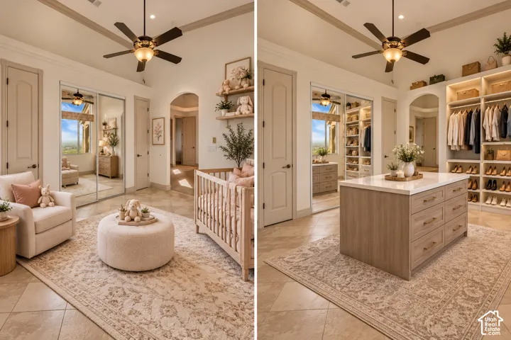 Tray ceiling with a decorative ceiling fan, arched doorway, and built-in closet with integrated lighting