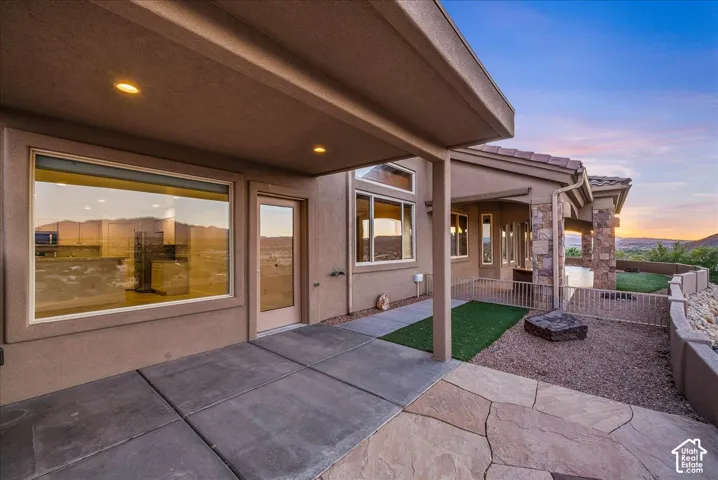 Expansive covered patio featuring concrete and flagstone paving, recessed lighting, a glass-paneled exterior door, and large windows