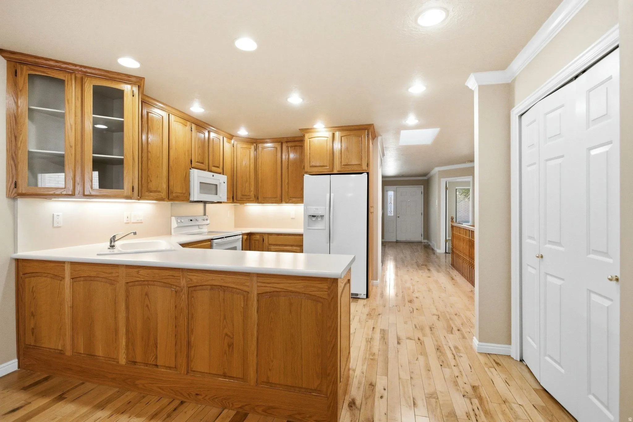 Spacious kitchen featuring wood cabinetry, white countertops, and integrated appliances