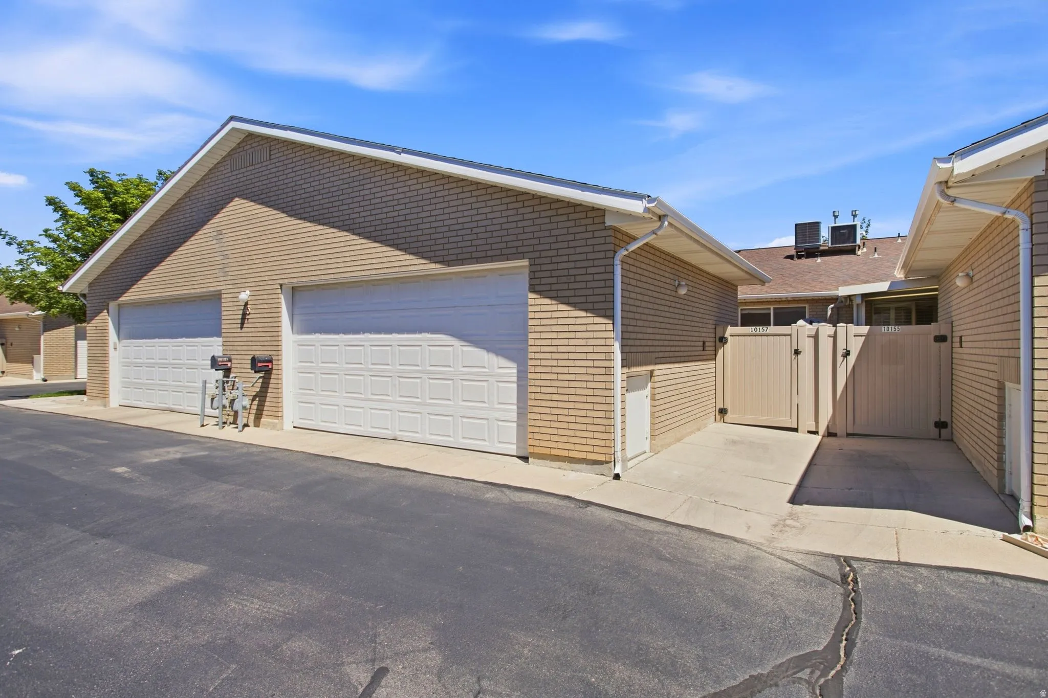 Two-car garage with brick veneer and horizontal siding