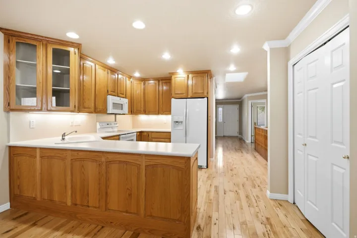 Spacious kitchen featuring wood cabinetry, white countertops, and integrated appliances