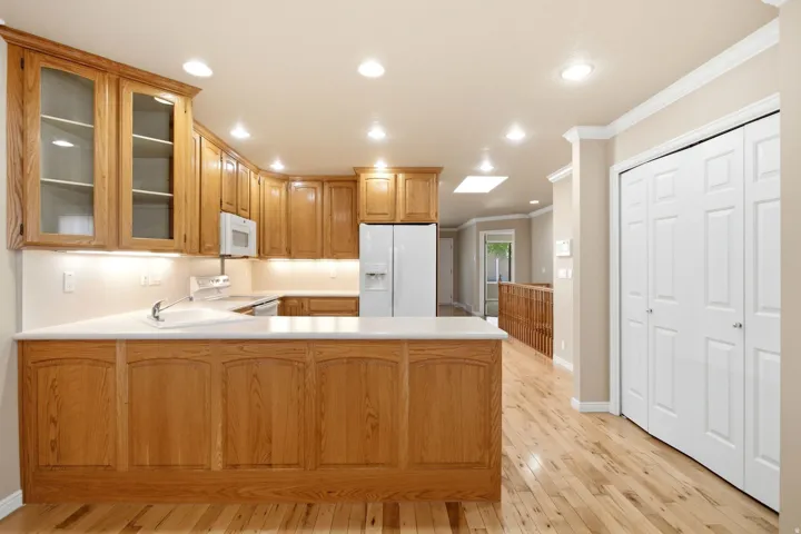 Kitchen featuring honey-toned wood cabinetry, white countertops, and recessed lighting