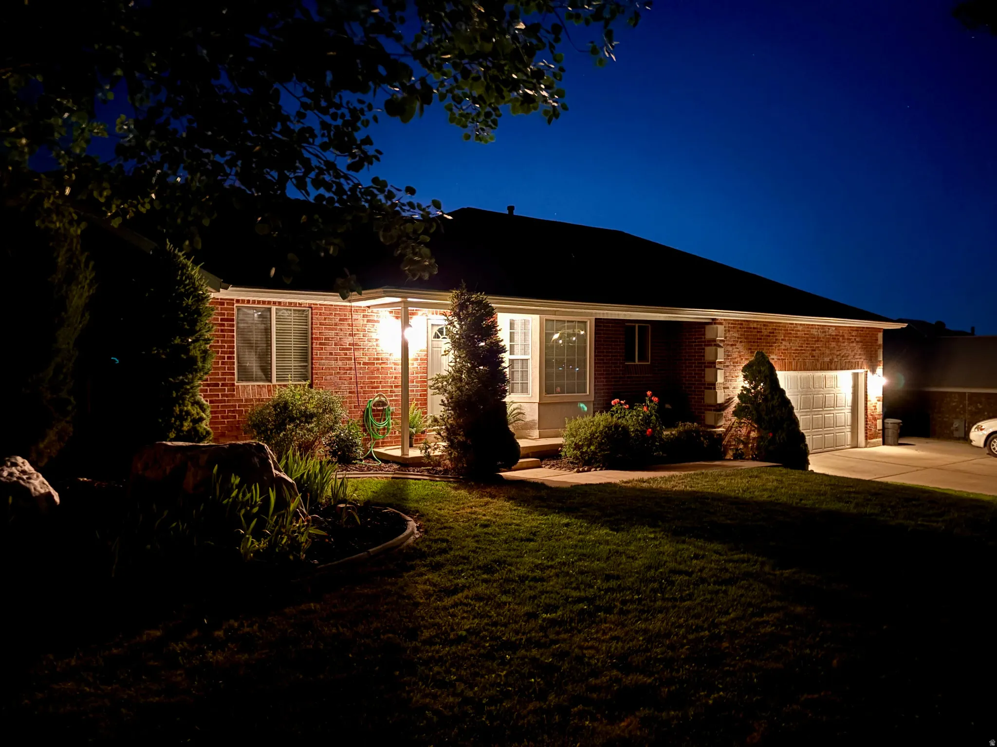 Red brick exterior with a porch light illuminating the entryway