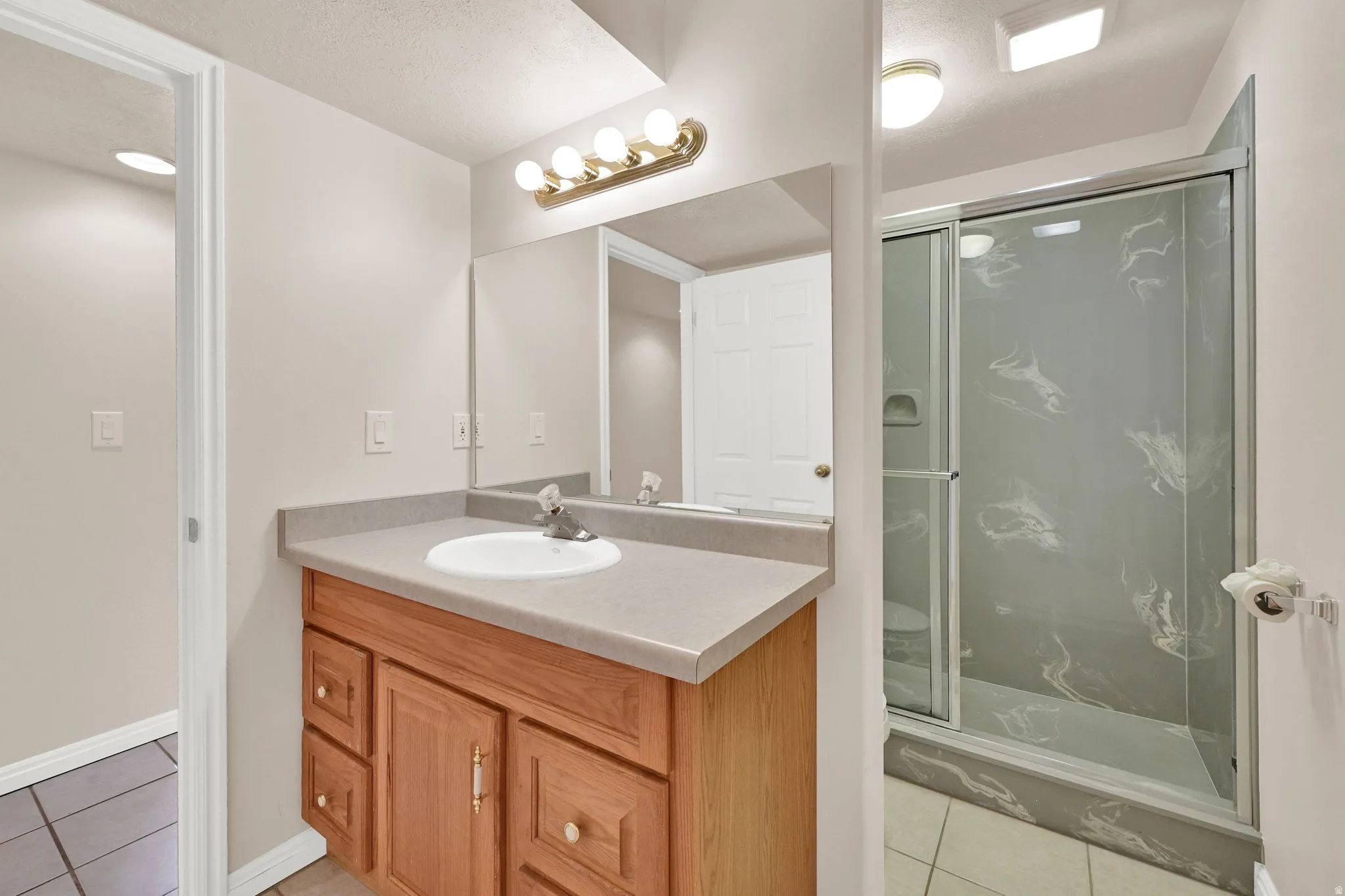 Bathroom vanity featuring a single basin sink and wood-finish cabinetry