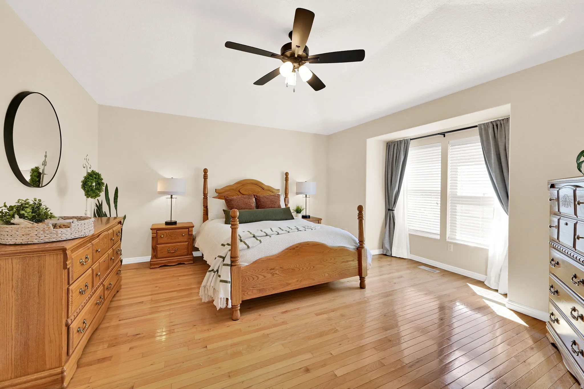 Spacious room featuring wood-finish flooring, a vaulted ceiling, and a ceiling fan