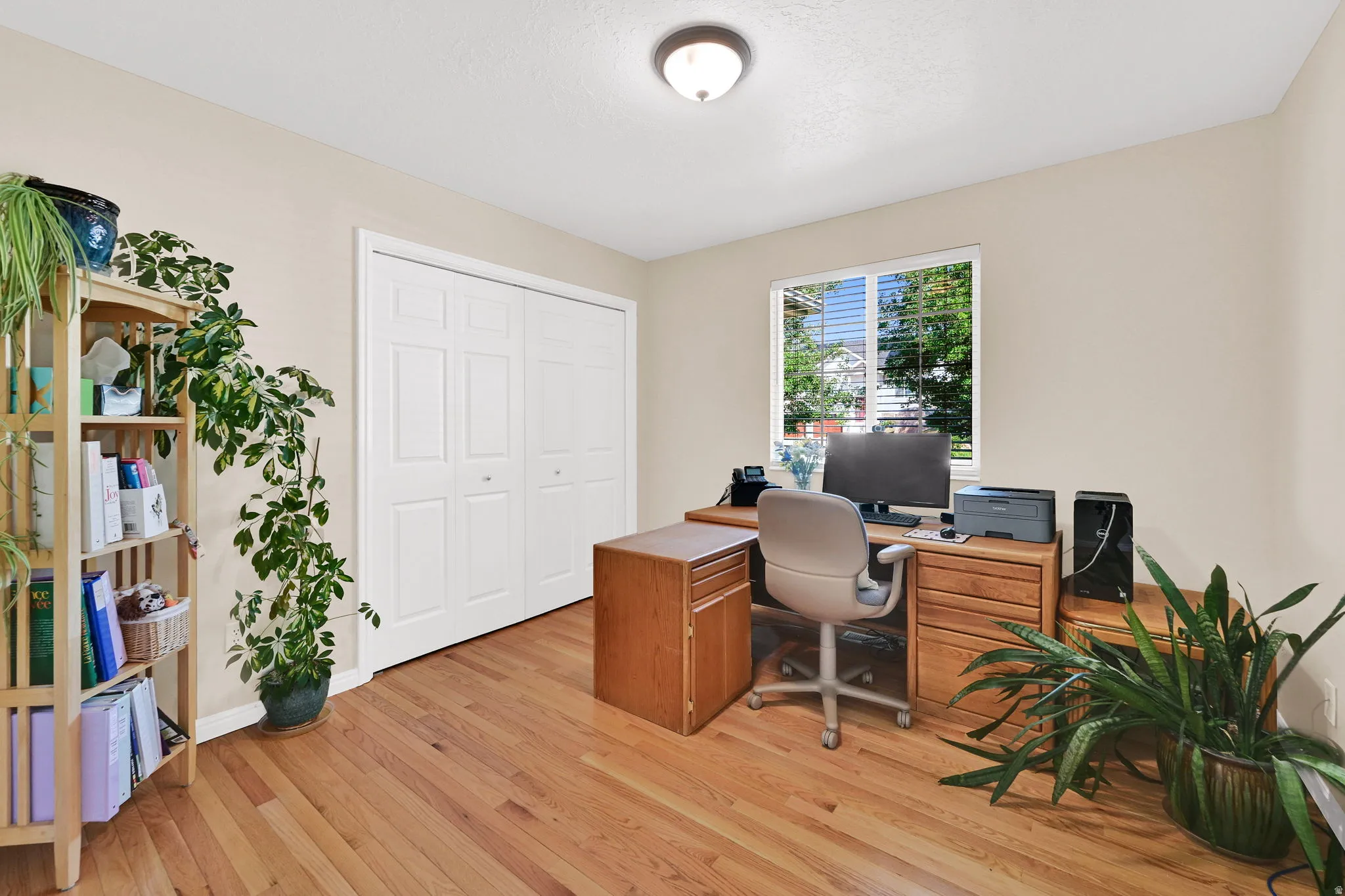 Interior room featuring hardwood flooring, a window with blinds, and painted walls