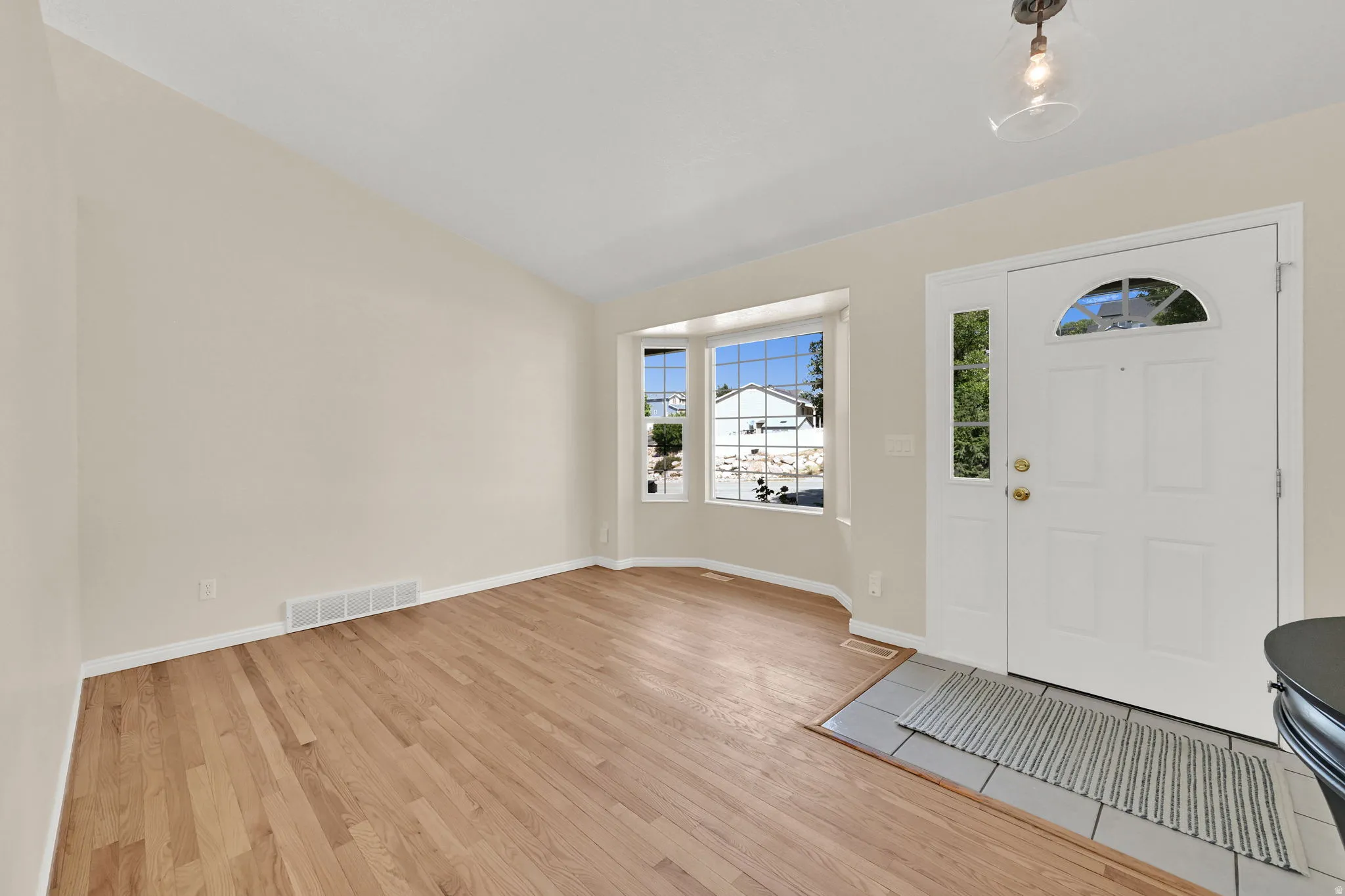 Entry foyer with wood-finish flooring and a tiled landing