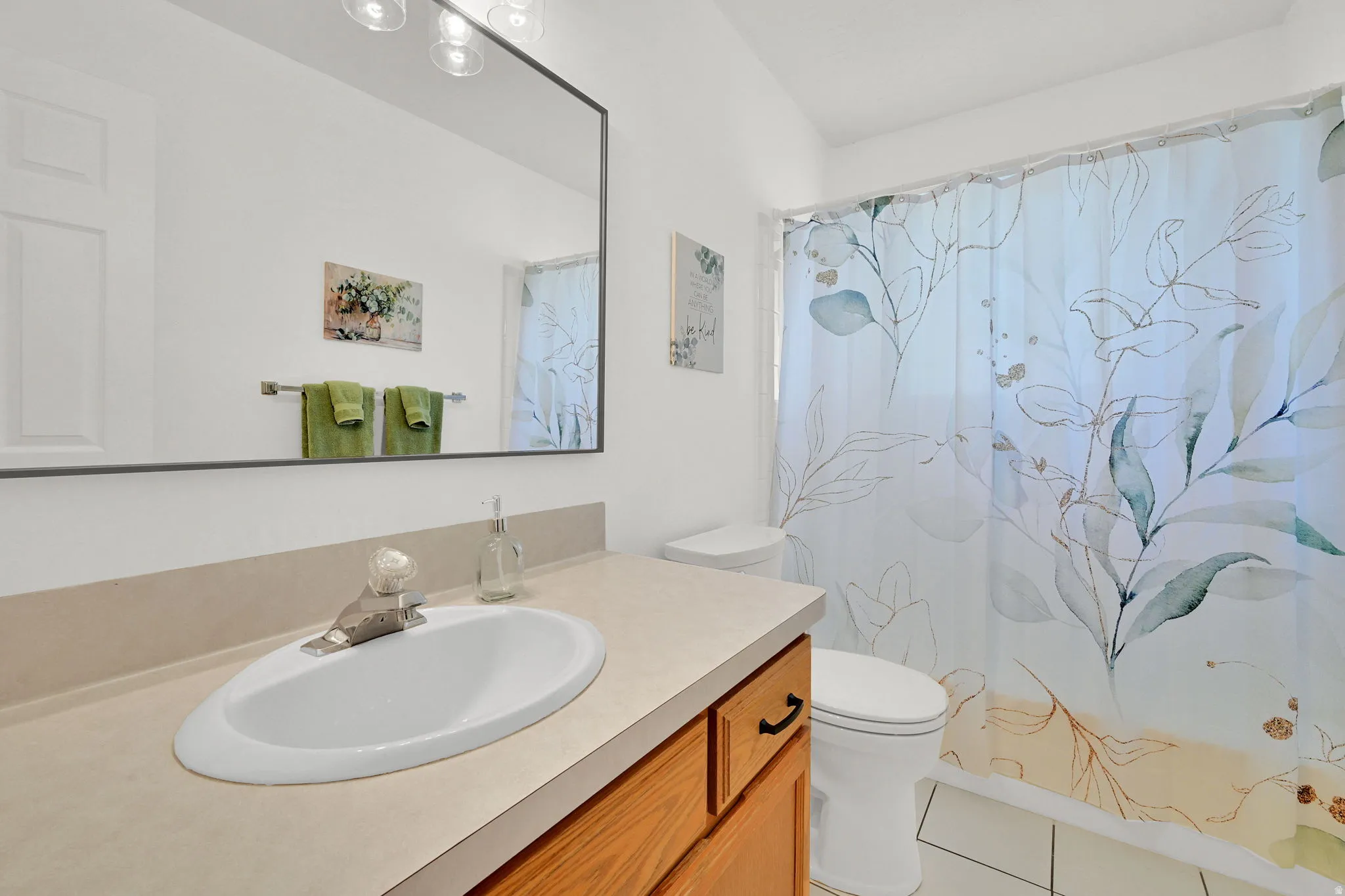 Bathroom vanity featuring an integrated sink, laminate countertop, and wood-finish cabinetry