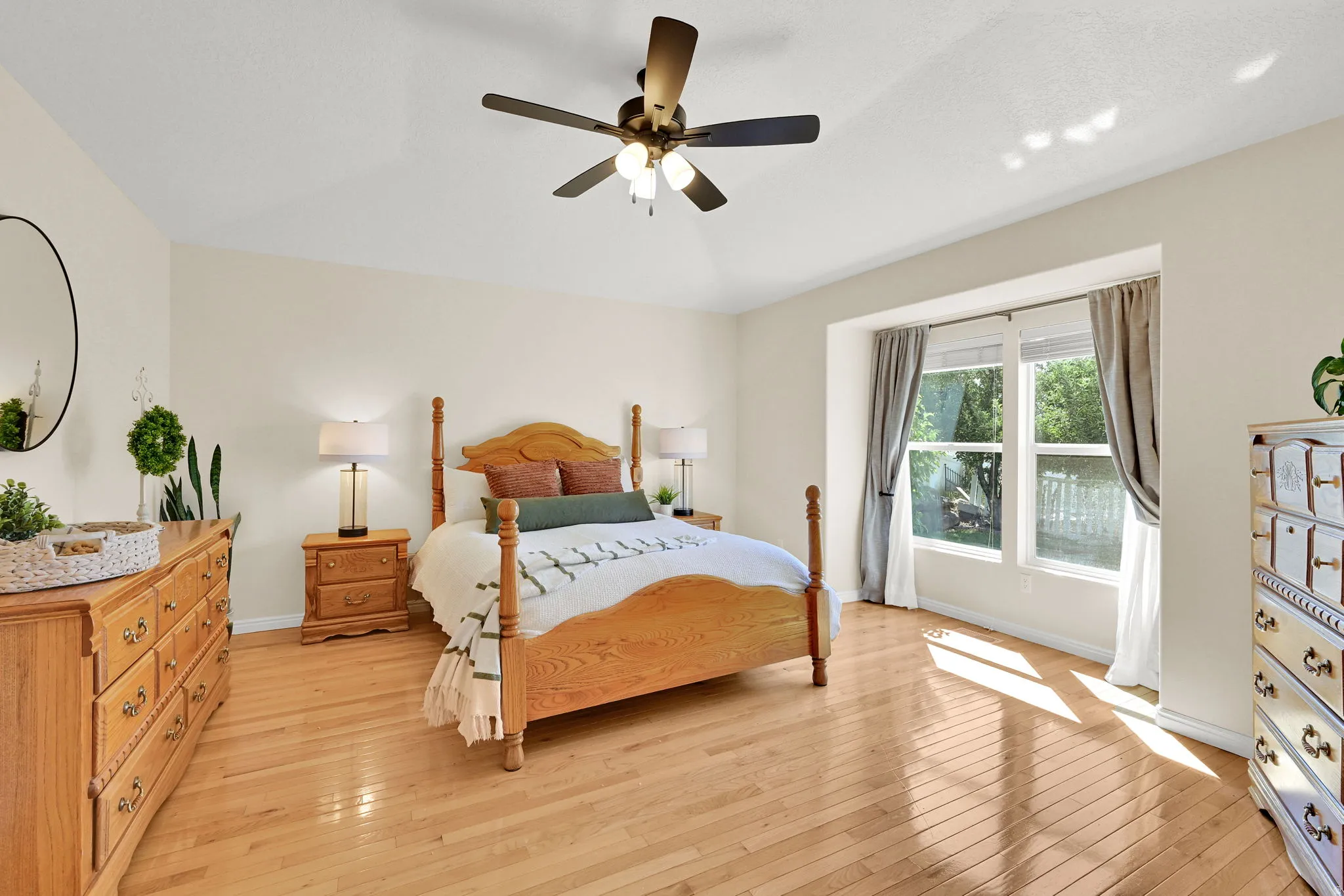 Vaulted ceiling with a ceiling fan, light wood-finish flooring, and recessed window