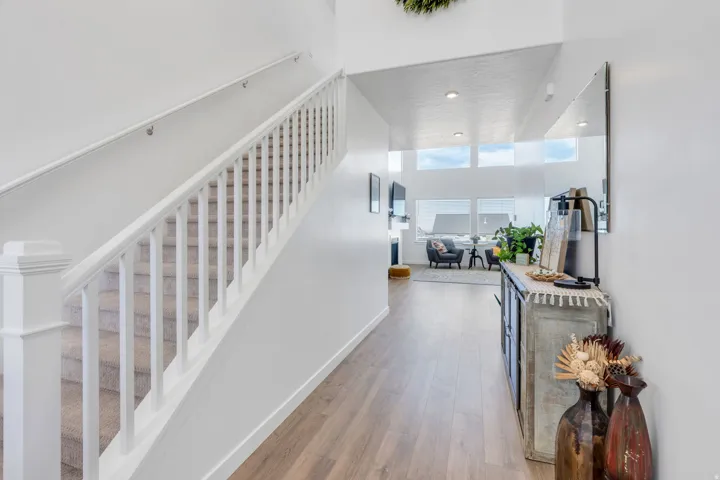 Entryway featuring wood-finish flooring and a staircase with white balusters