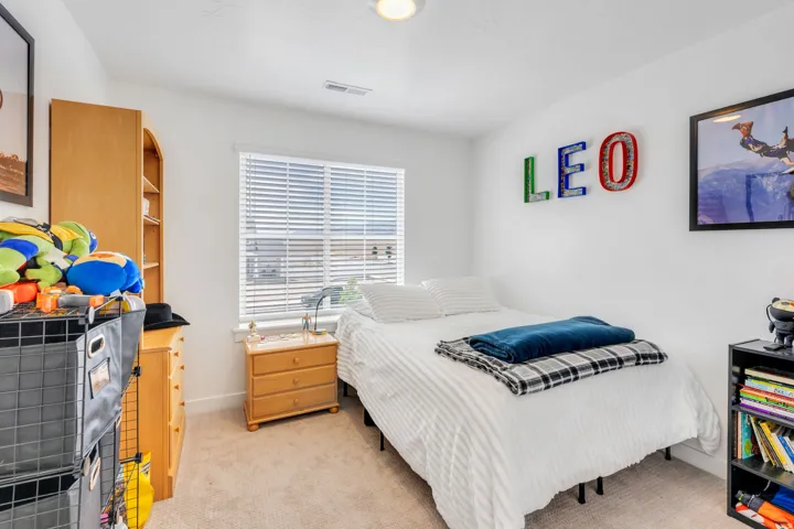 Carpeted room featuring a single window with horizontal blinds, built-in recessed lighting, light-colored walls, and a light wood-finish built-in shelving unit