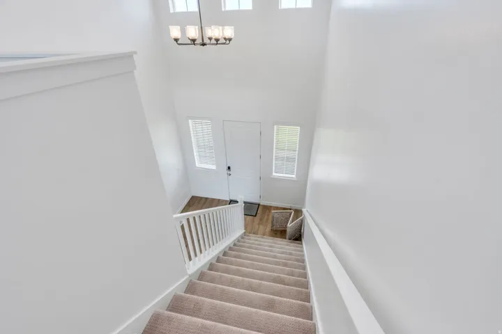 Foyer with high ceilings, an elegant chandelier, and wood-finish flooring