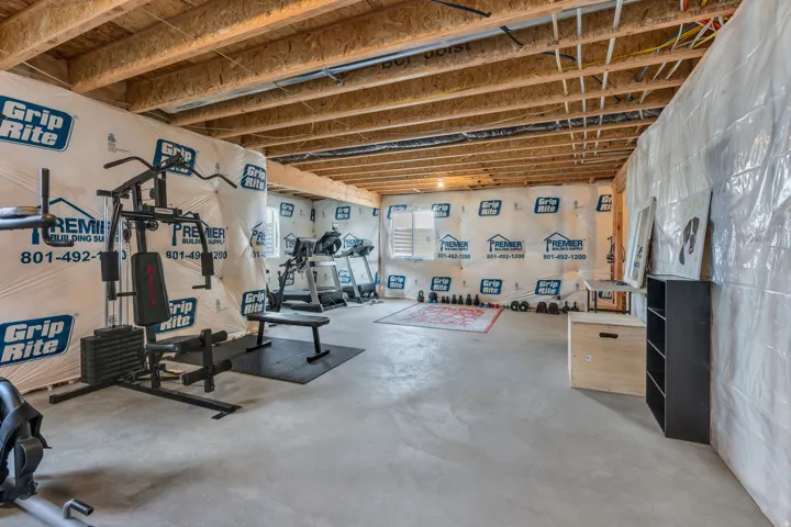Unfinished basement featuring exposed wood joists and concrete flooring