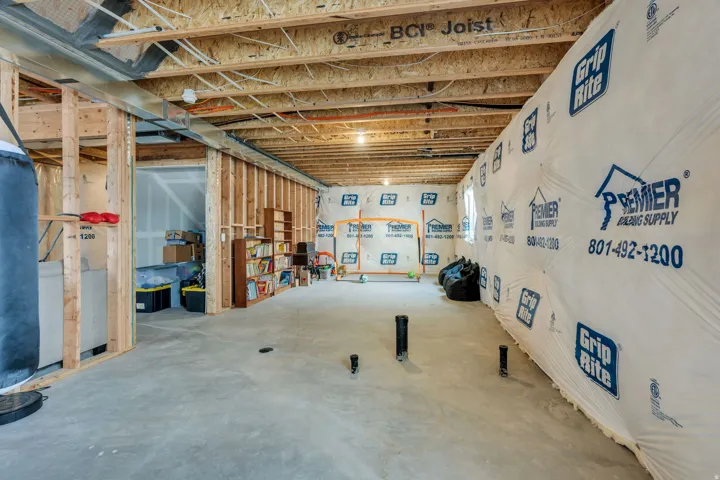Unfinished basement featuring exposed wood joists and structural framing
