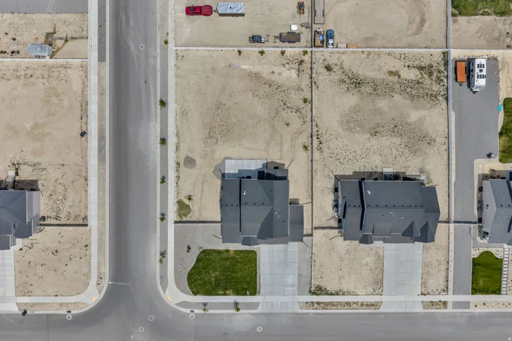 Contemporary residence with a dark grey roof, a concrete driveway, and a front lawn