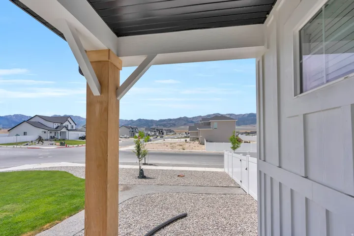Inviting front porch featuring a natural wood-finish column, white trim, and a dark soffit