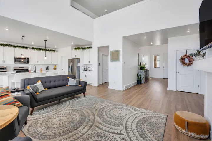 Open-concept living area with wood-finish flooring extending into the kitchen and entryway