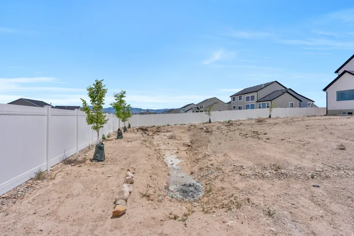 Expansive undeveloped lot featuring a white privacy fence