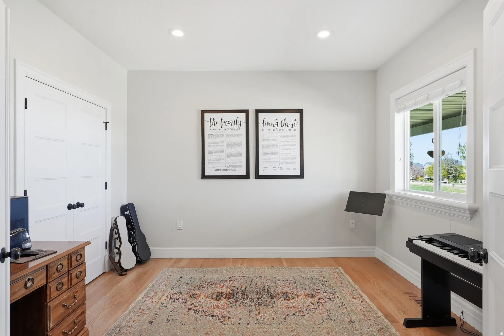 Light-filled room featuring wood-finish flooring, recessed lighting, and a double-door closet