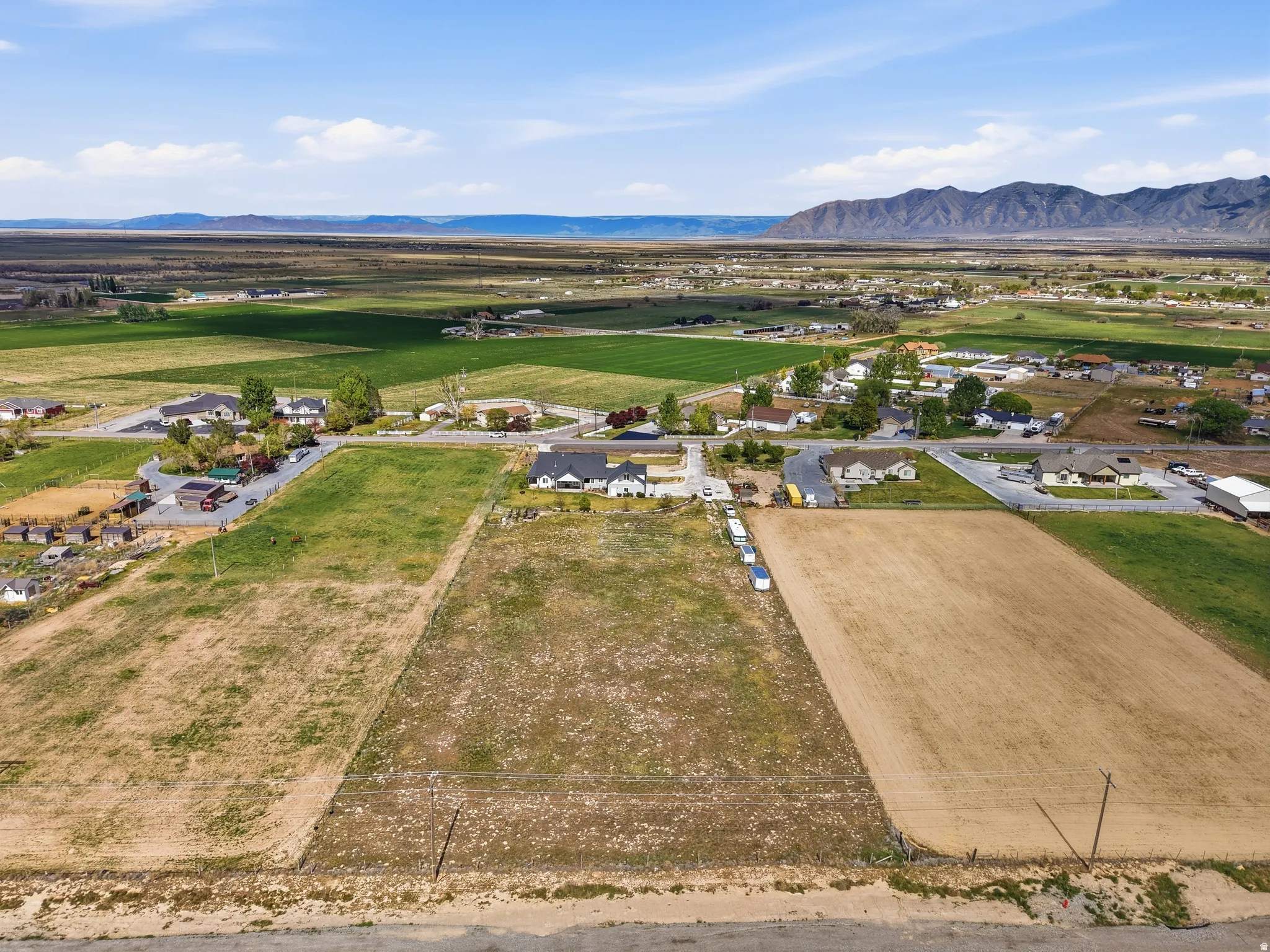 Expansive land parcel featuring a mix of open fields and distant mountain ranges